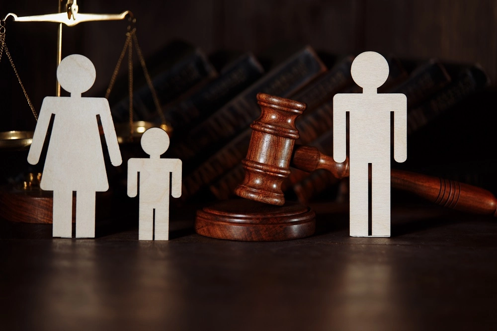 Wooden family figures, a gavel and scales of justice