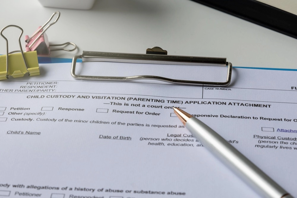 Child custody and visitation application form on a clipboard with a pen