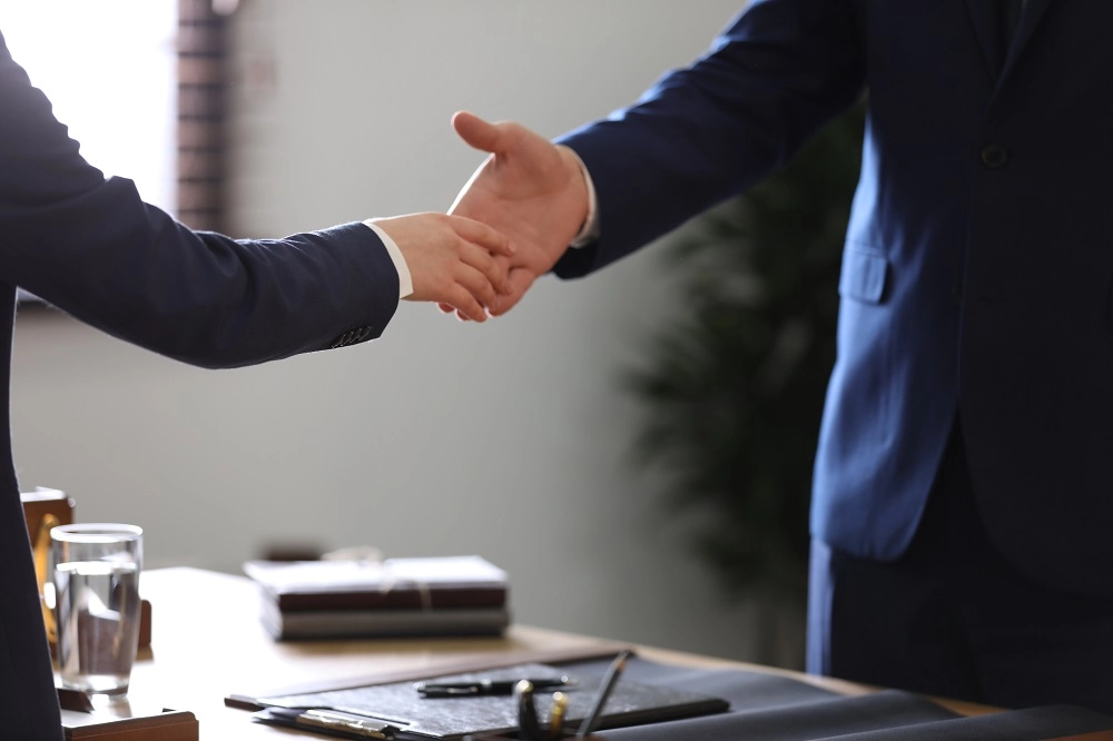 Attorney and client shaking hands in an office