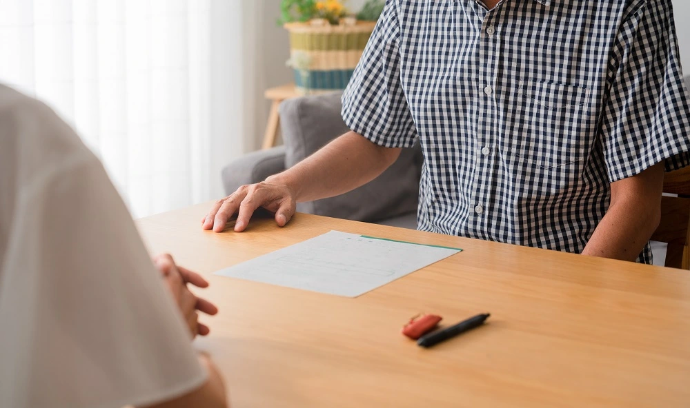 Two people sitting across a table with a blank agreement