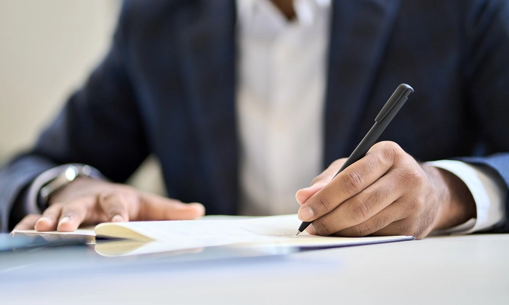 Professional in a suit writing a report