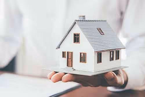 Hand holding a small model house