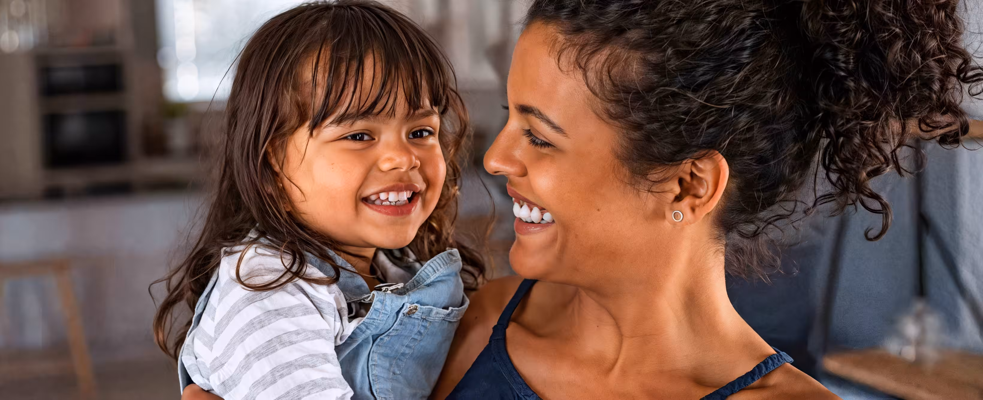 Smiling mother and young daughter face to face