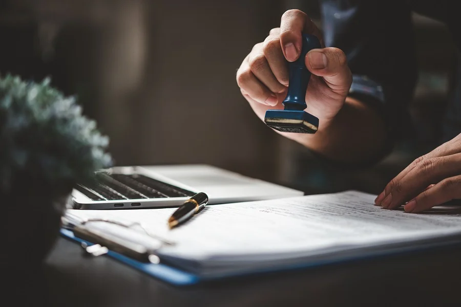 Hand stamping a document on a desk